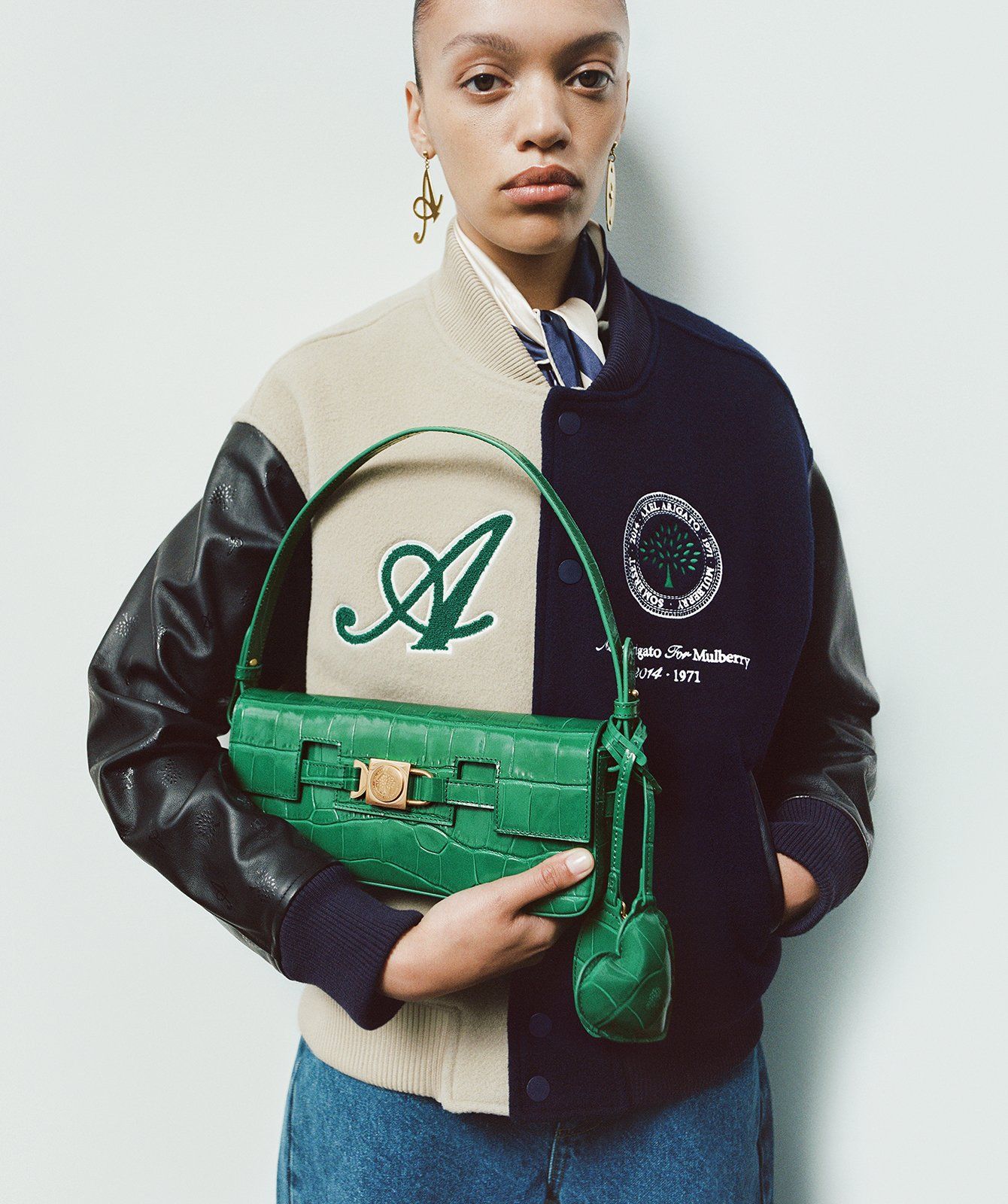 model holding Axel Arigato for Mulberry Shoulder Bag in emerald green